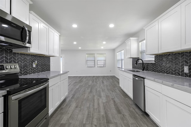810 W Cattle Dr, Onalaska, TX 77360 - kitchen featuring appliances with stainless steel finishes, tasteful backsplash, recessed lighting, and white cabinets