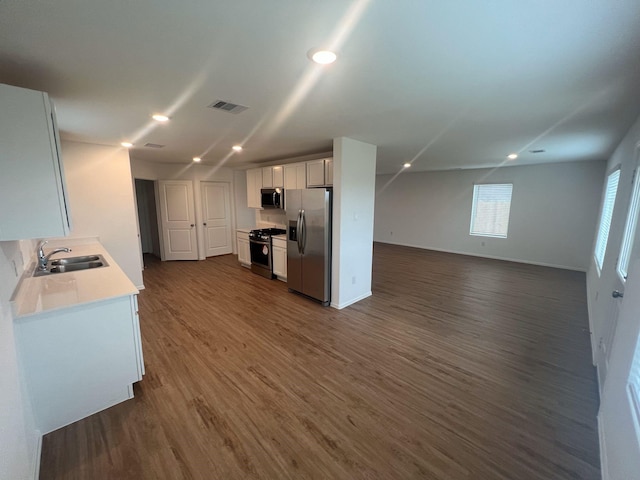 4127 Neches Bend Dr, Baytown, TX 77521 - kitchen featuring appliances with stainless steel finishes, open floor plan, dark wood-style flooring, light countertops, and white cabinetry