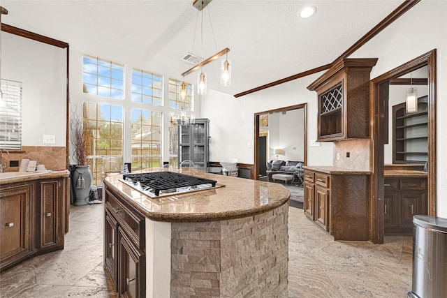 6710 Blue Hills Rd, Houston, TX 77069 - kitchen featuring stainless steel gas cooktop, open floor plan, crown molding, light stone counters, and dark brown cabinetry