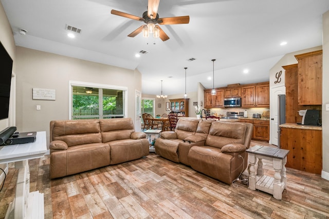 6112 Guyler St, Wallis, TX 77485 - living area with light wood finished floors, a ceiling fan, recessed lighting, lofted ceiling, and a chandelier