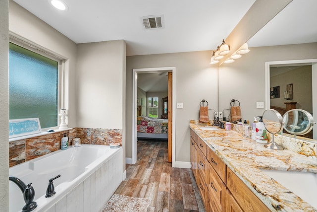 6112 Guyler St, Wallis, TX 77485 - full bathroom featuring ensuite bath, a garden tub, double vanity, and wood finished floors