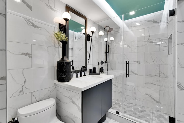 1400 Hermann Dr Unit 10C, Houston, TX 77004 - bathroom featuring a marble finish shower, tile walls, and vanity