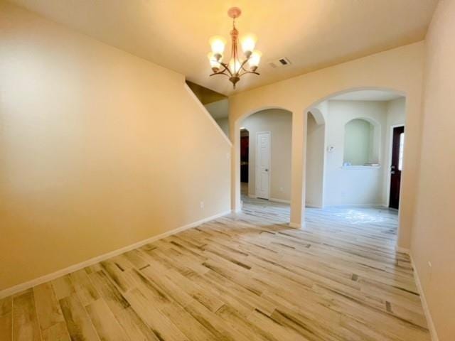 14706 Branchwest Dr, Houston, TX 77082 - empty room with a chandelier, arched walkways, and light wood finished floors
