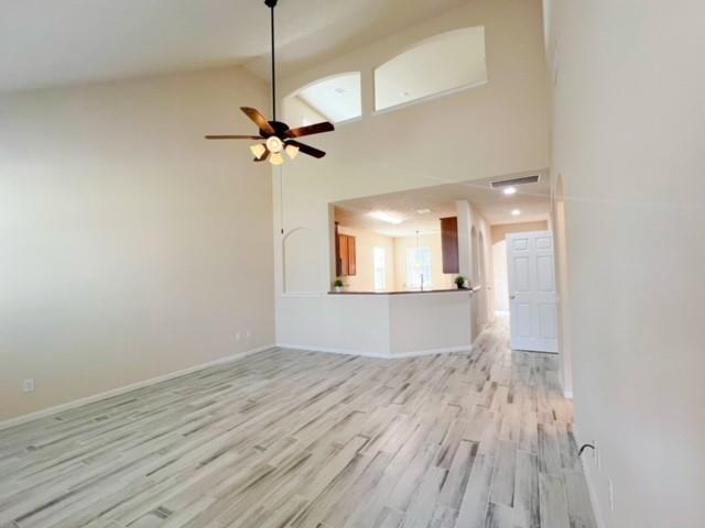 14706 Branchwest Dr, Houston, TX 77082 - unfurnished living room featuring light wood finished floors, high vaulted ceiling, and ceiling fan