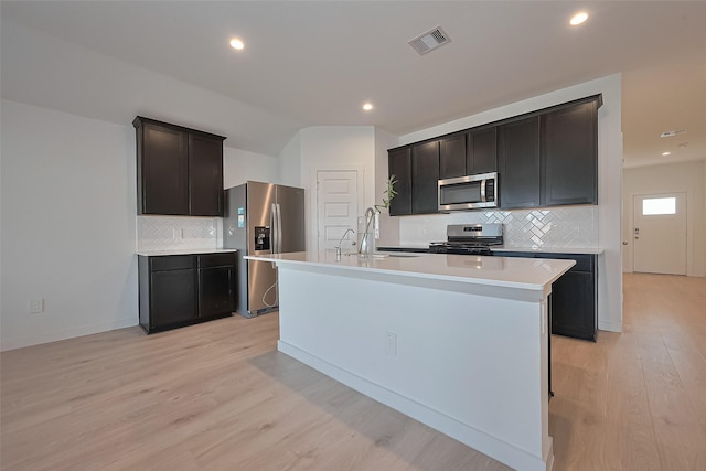 30119 Ousel Falls Ln, Katy, TX 77494 - kitchen with appliances with stainless steel finishes, tasteful backsplash, light wood-style flooring, light countertops, and recessed lighting
