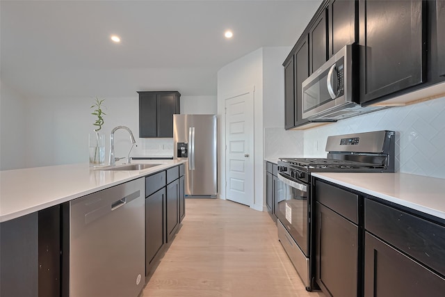 30119 Ousel Falls Ln, Katy, TX 77494 - kitchen featuring appliances with stainless steel finishes, backsplash, light countertops, light wood-style floors, and recessed lighting