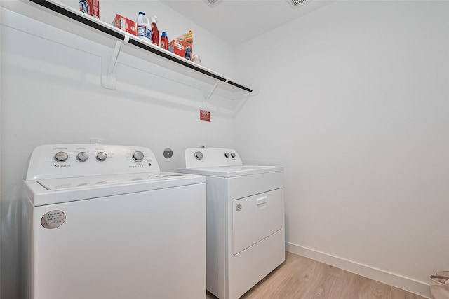 30119 Ousel Falls Ln, Katy, TX 77494 - laundry area with washing machine and dryer and light wood-style floors