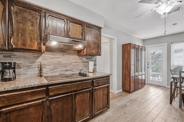 4957 Shadowbend Dr, Corpus Christi, TX 78413 - kitchen featuring under cabinet range hood, black electric stovetop, ceiling fan, dark brown cabinets, and backsplash