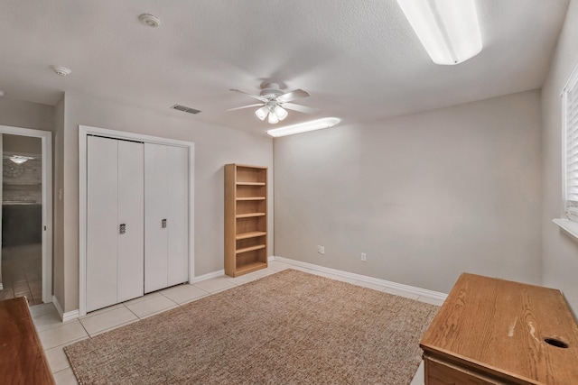 4957 Shadowbend Dr, Corpus Christi, TX 78413 - unfurnished bedroom featuring light tile patterned flooring, a closet, a ceiling fan, and a textured ceiling