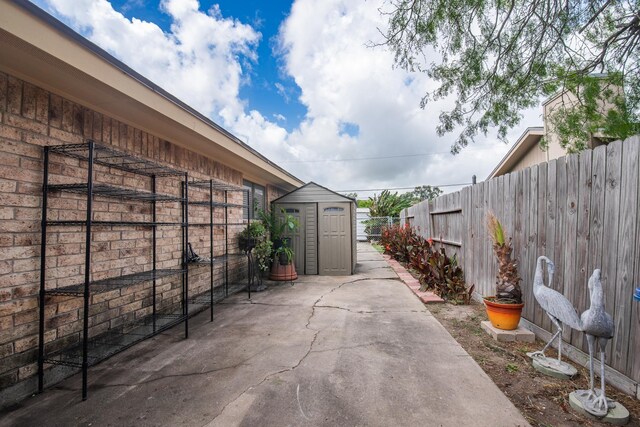 4957 Shadowbend Dr, Corpus Christi, TX 78413 - fenced backyard featuring a storage unit and a patio area