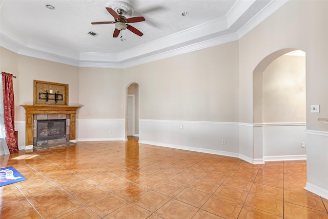 15908 Mcnorton, Splendora, TX 77372 - unfurnished living room with arched walkways, a ceiling fan, a tray ceiling, light tile patterned floors, and a tile fireplace