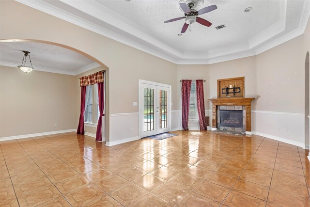 15908 Mcnorton, Splendora, TX 77372 - unfurnished living room featuring arched walkways, a ceiling fan, light tile patterned flooring, crown molding, and a raised ceiling