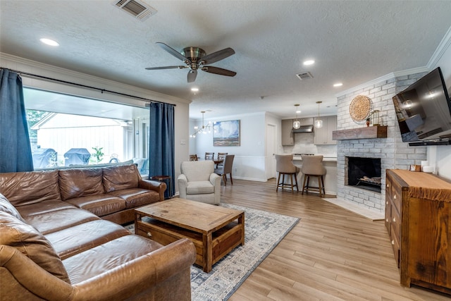 2827 Fontana Dr, Houston, TX 77043 - living area featuring crown molding, a textured ceiling, a ceiling fan, light wood finished floors, and a fireplace