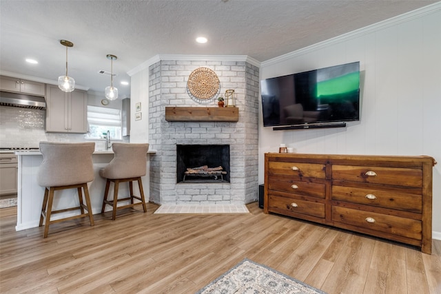 2827 Fontana Dr, Houston, TX 77043 - living room with light wood-style floors, a fireplace, crown molding, a textured ceiling, and recessed lighting
