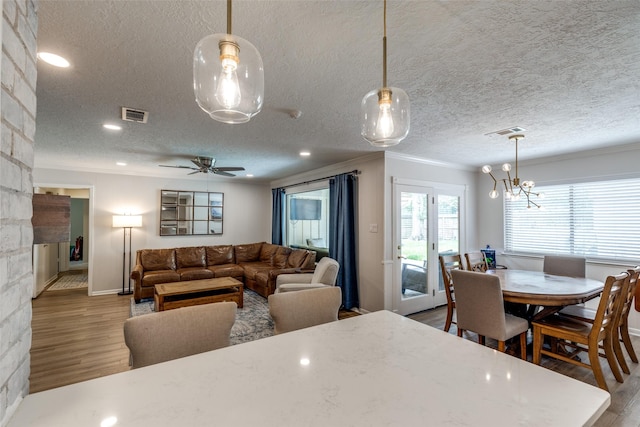 2827 Fontana Dr, Houston, TX 77043 - dining space with ornamental molding, wood finished floors, a textured ceiling, a ceiling fan, and a chandelier