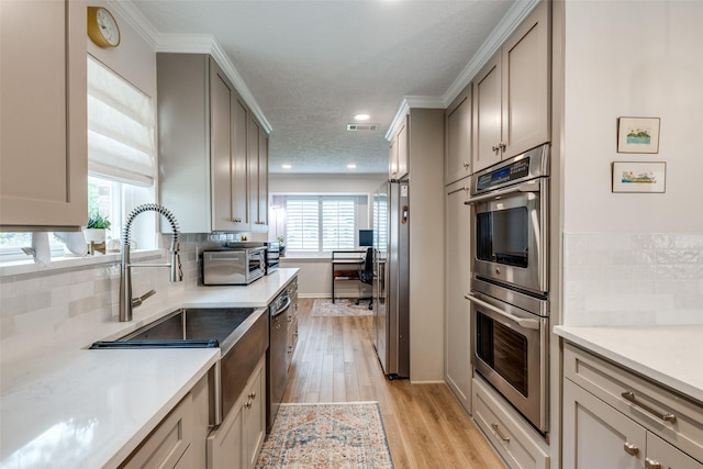 2827 Fontana Dr, Houston, TX 77043 - kitchen featuring appliances with stainless steel finishes, decorative backsplash, light wood-type flooring, light countertops, and ornamental molding