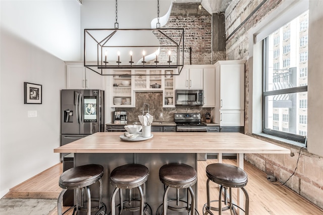 705 Main St Unit 801, Houston, TX 77002 - kitchen with appliances with stainless steel finishes, wood counters, a towering ceiling, healthy amount of natural light, and a breakfast bar area