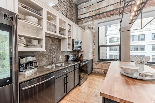 705 Main St Unit 801, Houston, TX 77002 - kitchen featuring appliances with stainless steel finishes, butcher block counters, open shelves, light wood finished floors, and white cabinetry