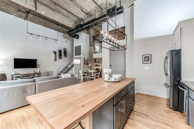 705 Main St Unit 801, Houston, TX 77002 - dining room featuring a towering ceiling, light wood finished floors, stairway, a chandelier, and rail lighting