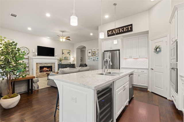 8903 Purdy Crescent Trl, Richmond, TX 77406 - kitchen with wine cooler, appliances with stainless steel finishes, dark wood-style flooring, recessed lighting, and a center island with sink
