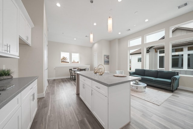 2504 W Tidwell Rd Unit C, Houston, TX 77091 - kitchen featuring wood finished floors, white cabinets, a kitchen island, recessed lighting, and hanging light fixtures
