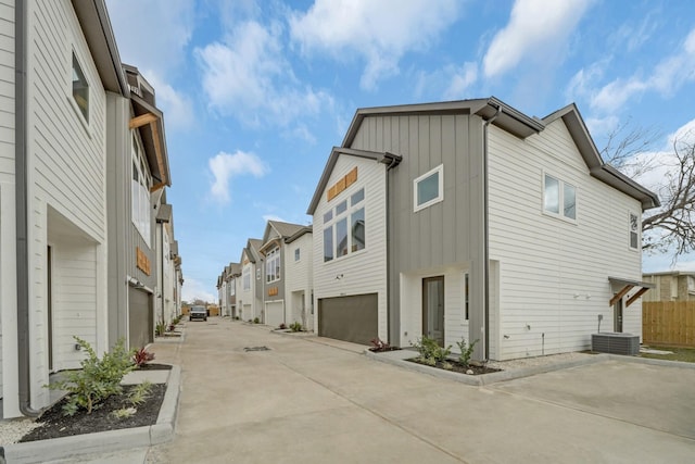 2504 W Tidwell Rd Unit C, Houston, TX 77091 - view of home's exterior featuring board and batten siding, an attached garage, driveway, and a residential view