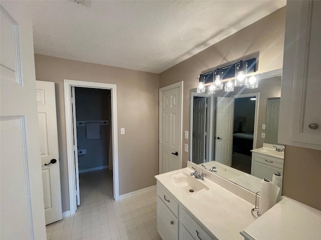 36218 Post Oak Cir, Magnolia, TX 77355 - ensuite bathroom with vanity, tile patterned floors, and a textured ceiling