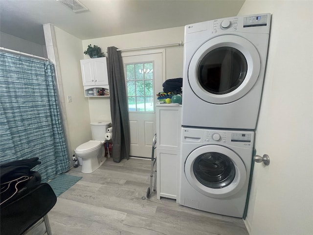36218 Post Oak Cir, Magnolia, TX 77355 - laundry room featuring stacked washer and clothes dryer and light wood finished floors