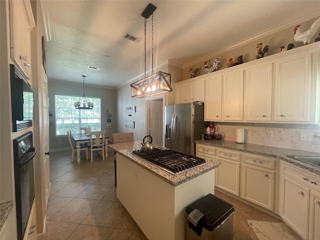 36218 Post Oak Cir, Magnolia, TX 77355 - kitchen featuring black appliances, ornamental molding, a chandelier, white cabinetry, and light tile patterned floors