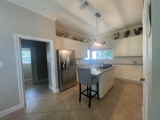 36218 Post Oak Cir, Magnolia, TX 77355 - kitchen with appliances with stainless steel finishes, healthy amount of natural light, white cabinetry, a textured ceiling, and ornamental molding