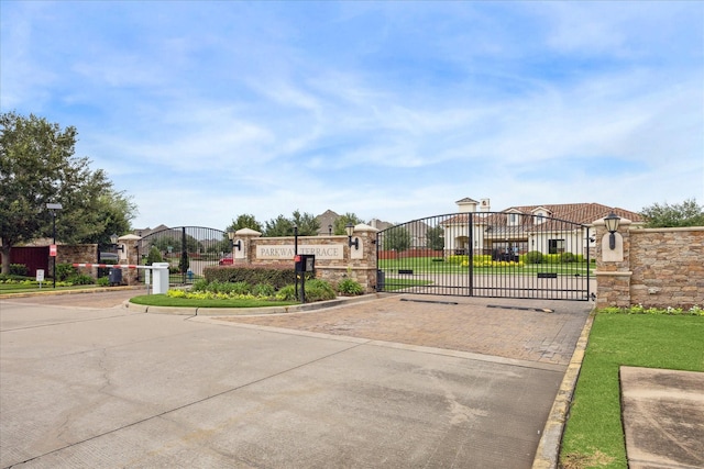 13223 Parkway Spring Dr, Houston, TX 77077 - view of concrete road with a gate, curbs, and street lights