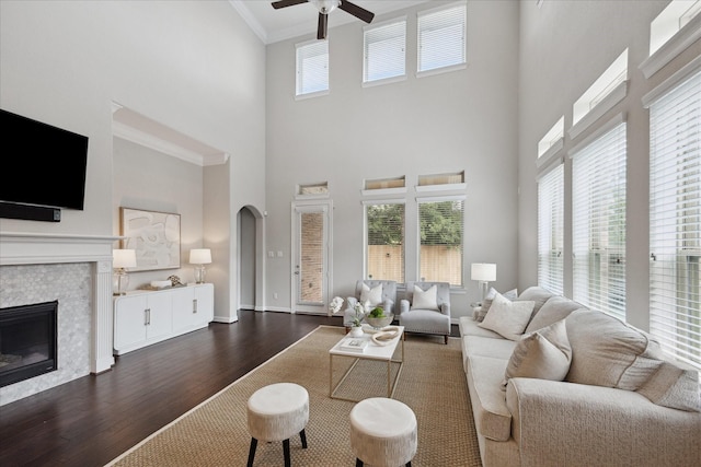 13223 Parkway Spring Dr, Houston, TX 77077 - living room with a ceiling fan, dark wood-style floors, arched walkways, a towering ceiling, and a tiled fireplace