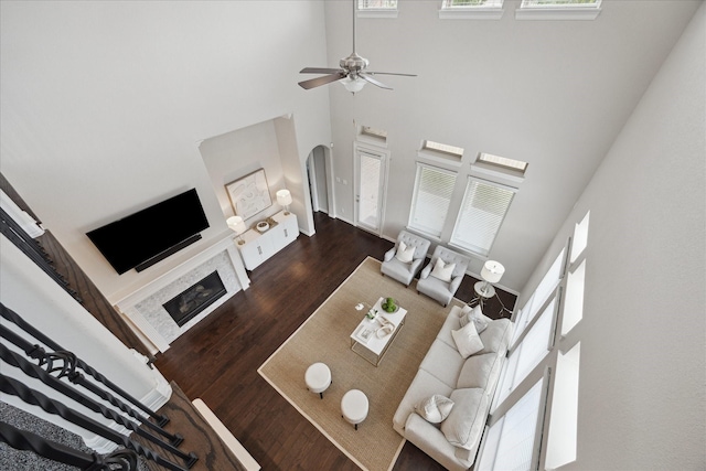 13223 Parkway Spring Dr, Houston, TX 77077 - living area featuring a towering ceiling, arched walkways, ceiling fan, wood finished floors, and a fireplace