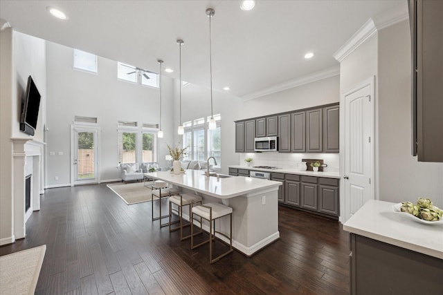 13223 Parkway Spring Dr, Houston, TX 77077 - kitchen featuring stainless steel microwave, gray cabinetry, open floor plan, a ceiling fan, and a kitchen bar