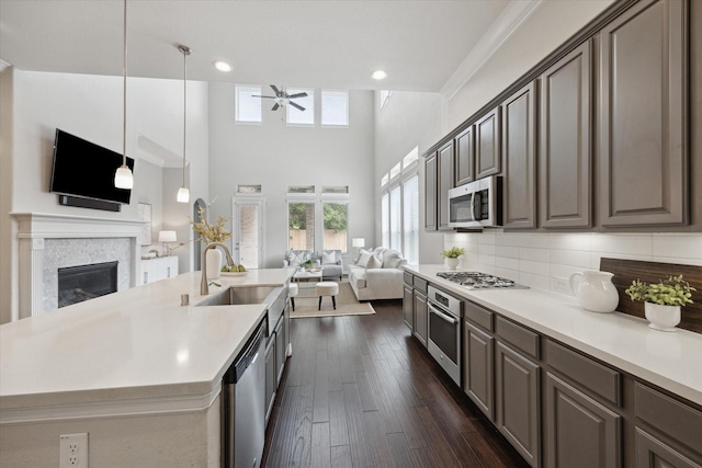 13223 Parkway Spring Dr, Houston, TX 77077 - kitchen featuring open floor plan, stainless steel appliances, a ceiling fan, light countertops, and a glass covered fireplace