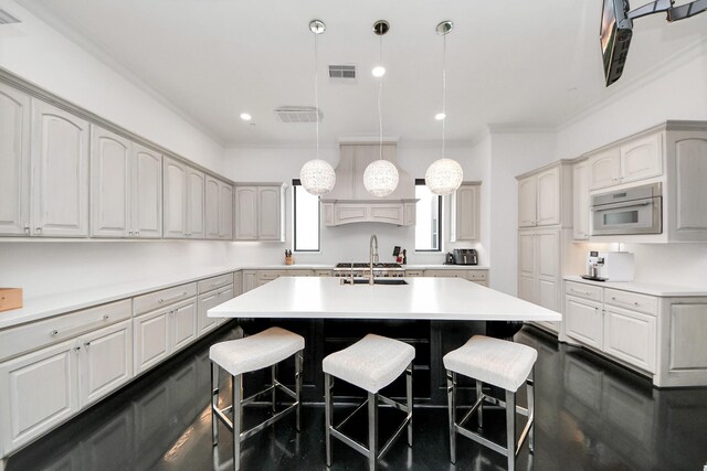 3711 Somerset Commons Ln, Houston, TX 77055 - kitchen with a kitchen breakfast bar, a kitchen island with sink, crown molding, light countertops, and hanging light fixtures