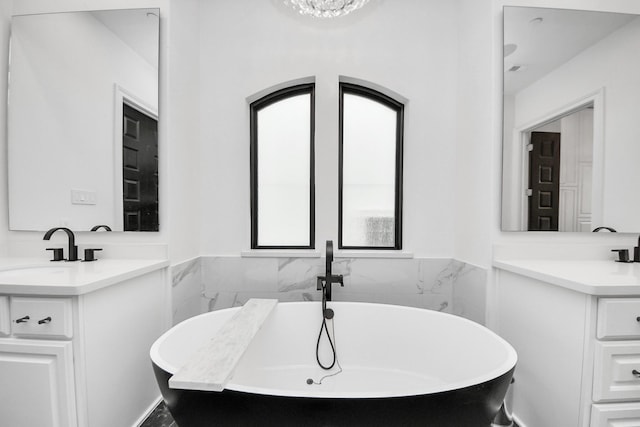 3711 Somerset Commons Ln, Houston, TX 77055 - full bathroom featuring two vanities, a freestanding tub, and wainscoting