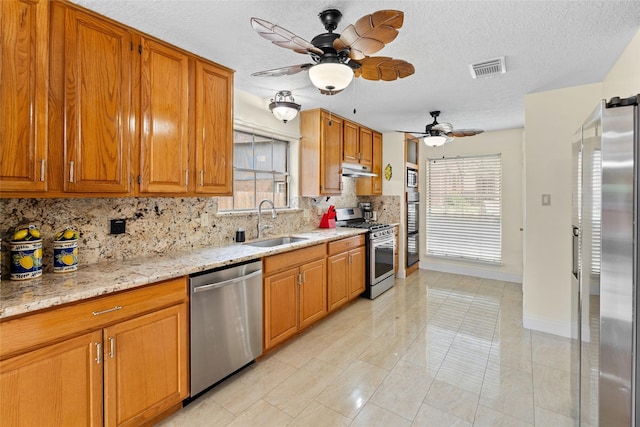 10422 Springland Ct, Houston, TX 77065 - kitchen with appliances with stainless steel finishes, backsplash, ceiling fan, under cabinet range hood, and a textured ceiling