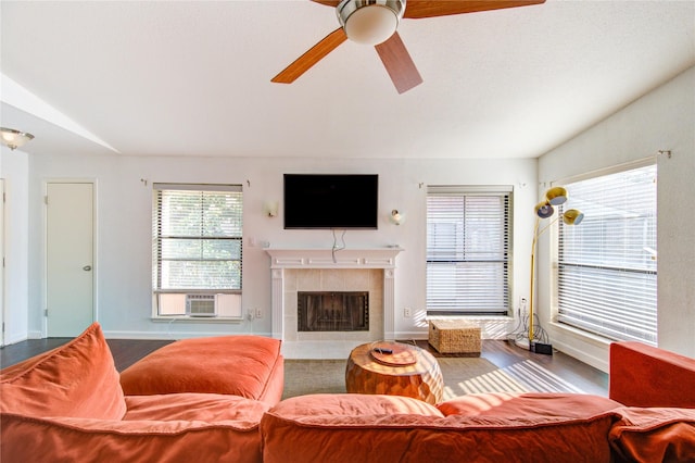 8100 Cambridge St Unit 114, Houston, TX 77054 - living area featuring cooling unit, a ceiling fan, a tiled fireplace, wood finished floors, and vaulted ceiling