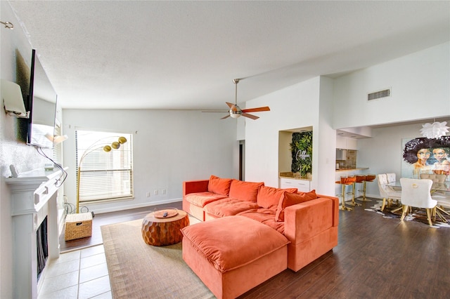 8100 Cambridge St Unit 114, Houston, TX 77054 - living area featuring ceiling fan, lofted ceiling, a fireplace, and wood finished floors
