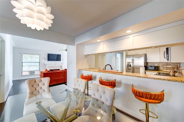 8100 Cambridge St Unit 114, Houston, TX 77054 - kitchen featuring appliances with stainless steel finishes, decorative backsplash, white cabinetry, light stone counters, and recessed lighting