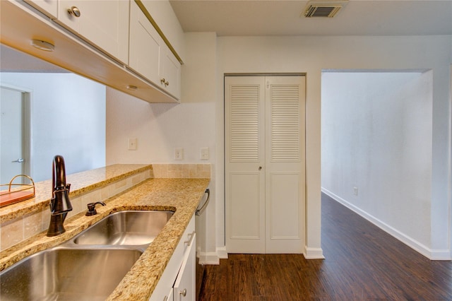 8100 Cambridge St Unit 114, Houston, TX 77054 - kitchen with dark wood-type flooring, white cabinets, and light stone counters