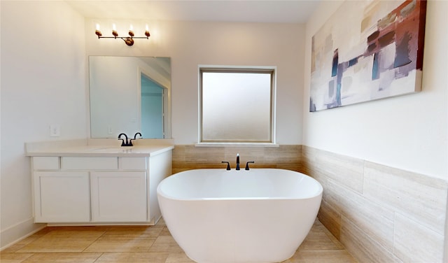 23604 Olive Creek Ln, New Caney, TX 77357 - bathroom with a soaking tub, vanity, tile patterned floors, and tile walls