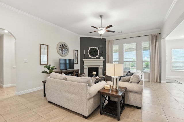 15415 Wildpoint Dr, Cypress, TX 77429 - living area with a ceiling fan, light tile patterned floors, crown molding, arched walkways, and a fireplace
