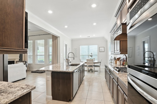 15415 Wildpoint Dr, Cypress, TX 77429 - kitchen with stainless steel appliances, dark brown cabinets, light stone counters, crown molding, and light tile patterned flooring