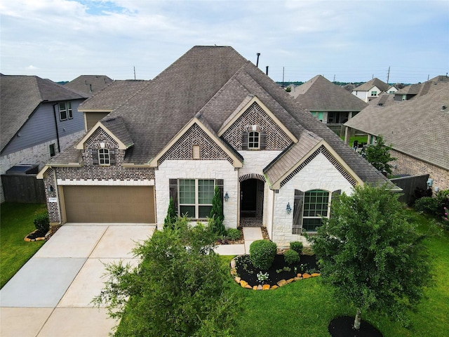 15415 Wildpoint Dr, Cypress, TX 77429 - french country style house featuring stone siding, concrete driveway, roof with shingles, a front yard, and a garage