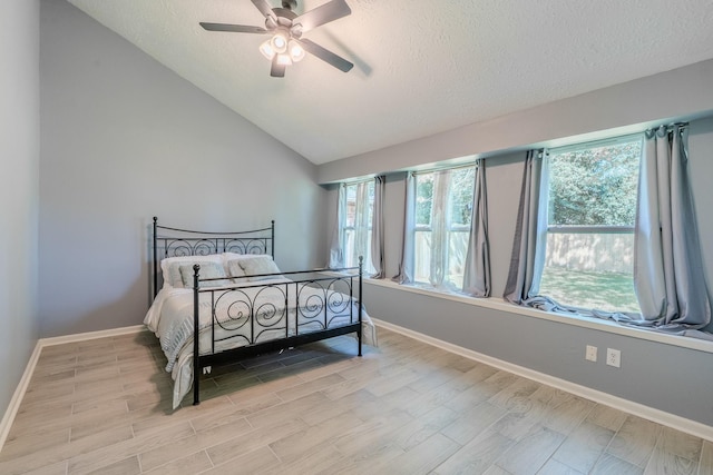 4218 E Terrace Creek Cir, Houston, TX 77014 - bedroom with light wood finished floors, a textured ceiling, multiple windows, a ceiling fan, and vaulted ceiling