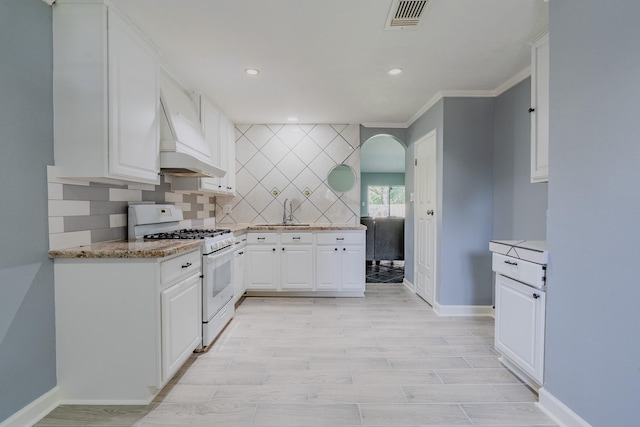 4218 E Terrace Creek Cir, Houston, TX 77014 - kitchen featuring white range with gas cooktop, custom range hood, tasteful backsplash, white cabinetry, and recessed lighting