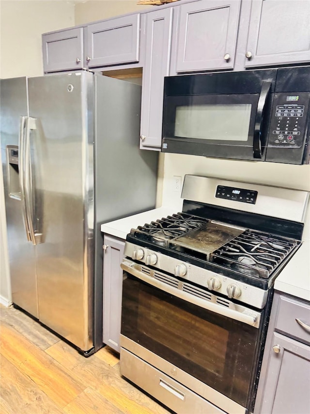 2702 Dovewood Ln, Spring, TX 77373 - kitchen featuring stainless steel appliances, light wood-type flooring, gray cabinetry, and light countertops