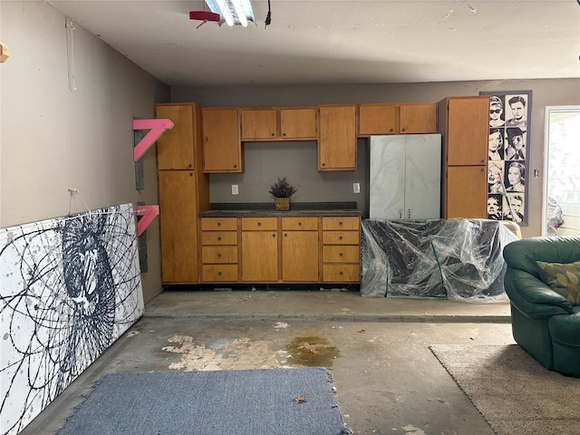 2702 Dovewood Ln, Spring, TX 77373 - kitchen featuring concrete flooring, dark countertops, and brown cabinetry